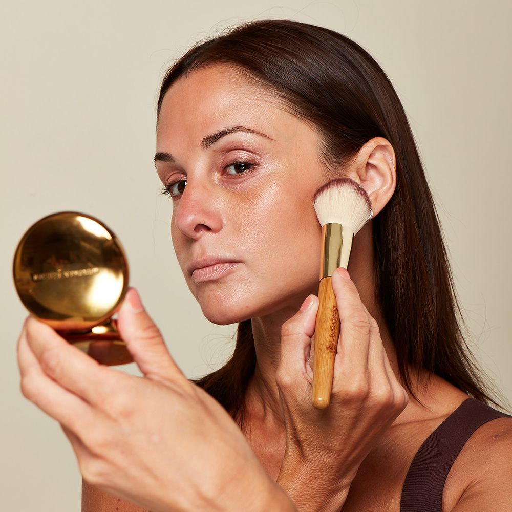 成熟肌肤的女性在使用古铜色化妆品