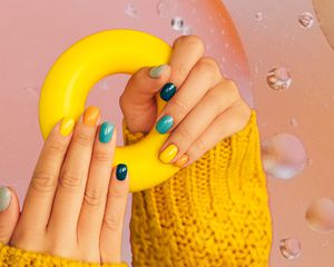 照片合成一个女人手里拿着一个橡胶圈,炫耀他们的彩色修指甲。
