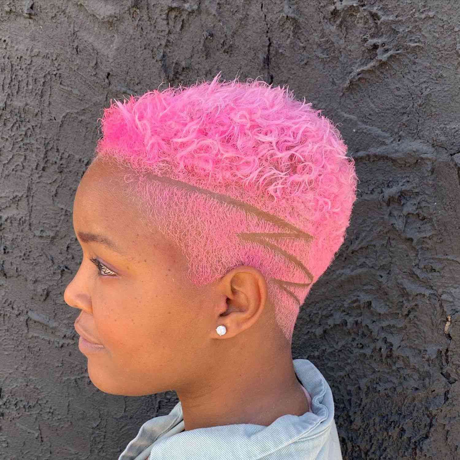 侧面观点的女人泡泡糖粉红色褪色的头发与之字形硬部分