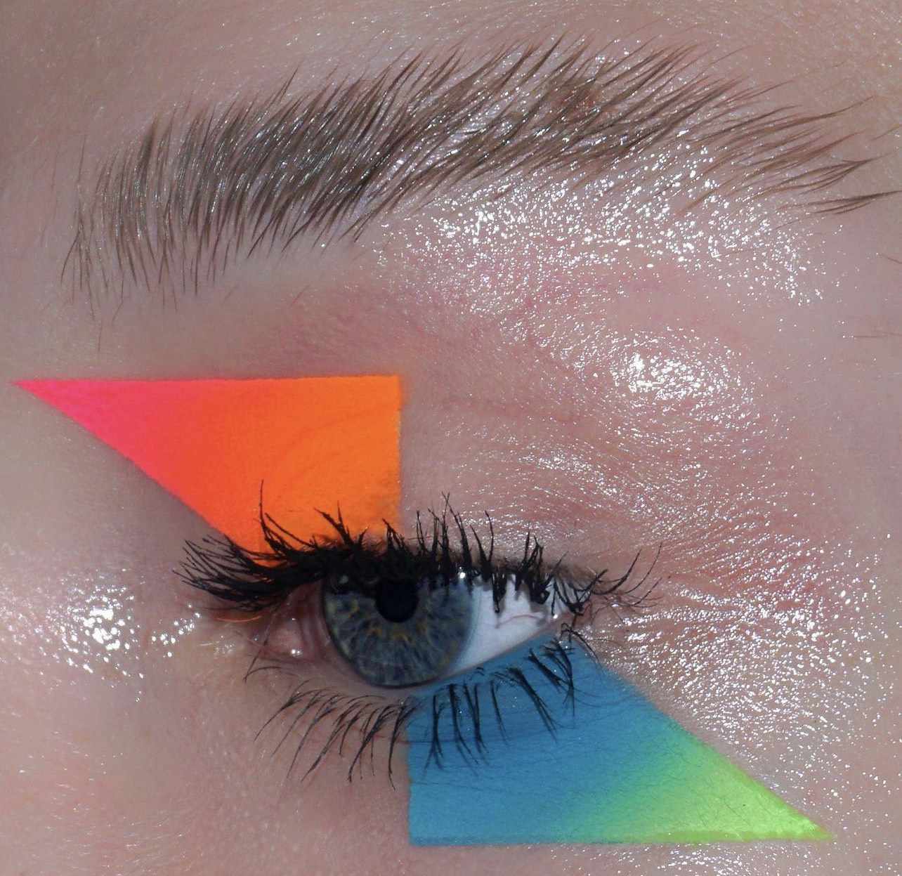 眼睛戴着霓虹灯显示图形的影子在霓虹灯橙色,粉色,蓝色,和绿色在尖锐的三角形形状上方和下方