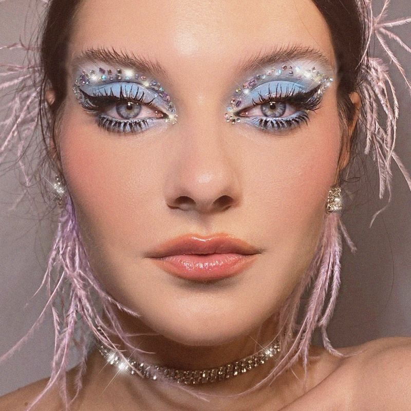 模特身着蓝色眼影用宝石和粉红色羽毛耳环