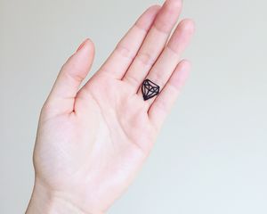 手指上有小钻石纹身的手
