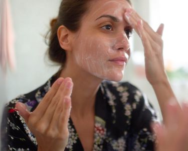 一位女士用治疗粉刺的药物洗脸
