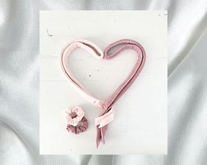 粉色无热的头发卷曲丝带排成一个心的形状
