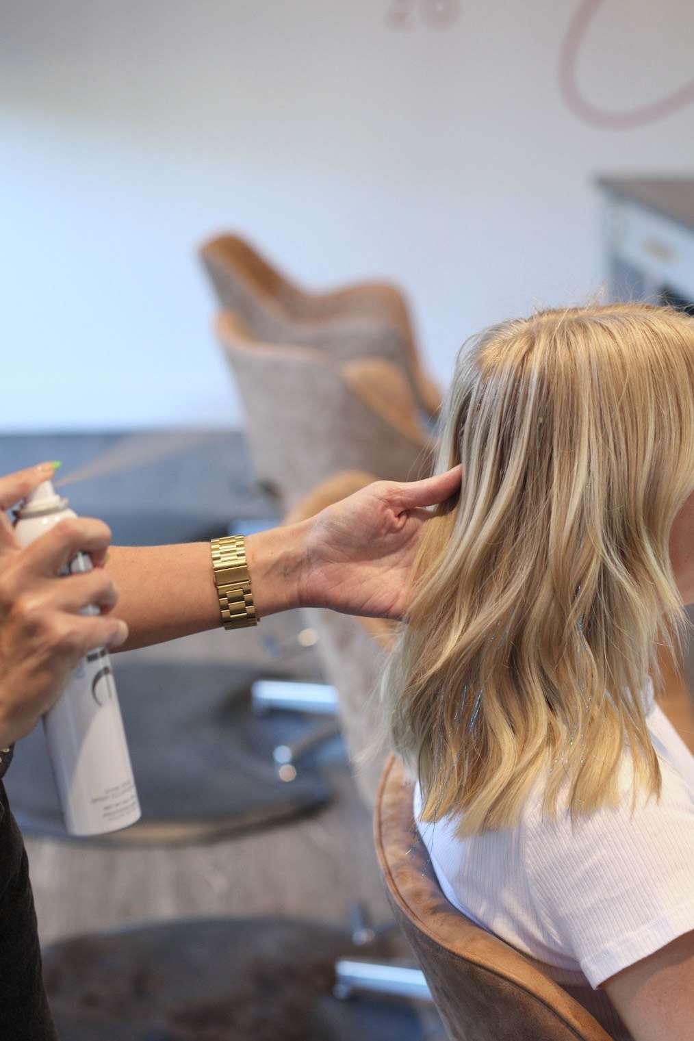杰西卡·佩奇正在给她客户的头发涂热保护剂