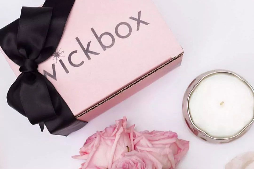 粉红色的Wickbox与黑色蝴蝶结蜡烛和粉红色的花朵