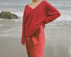 女人在海滩上穿着红色毛衣在丝绸吊带裙