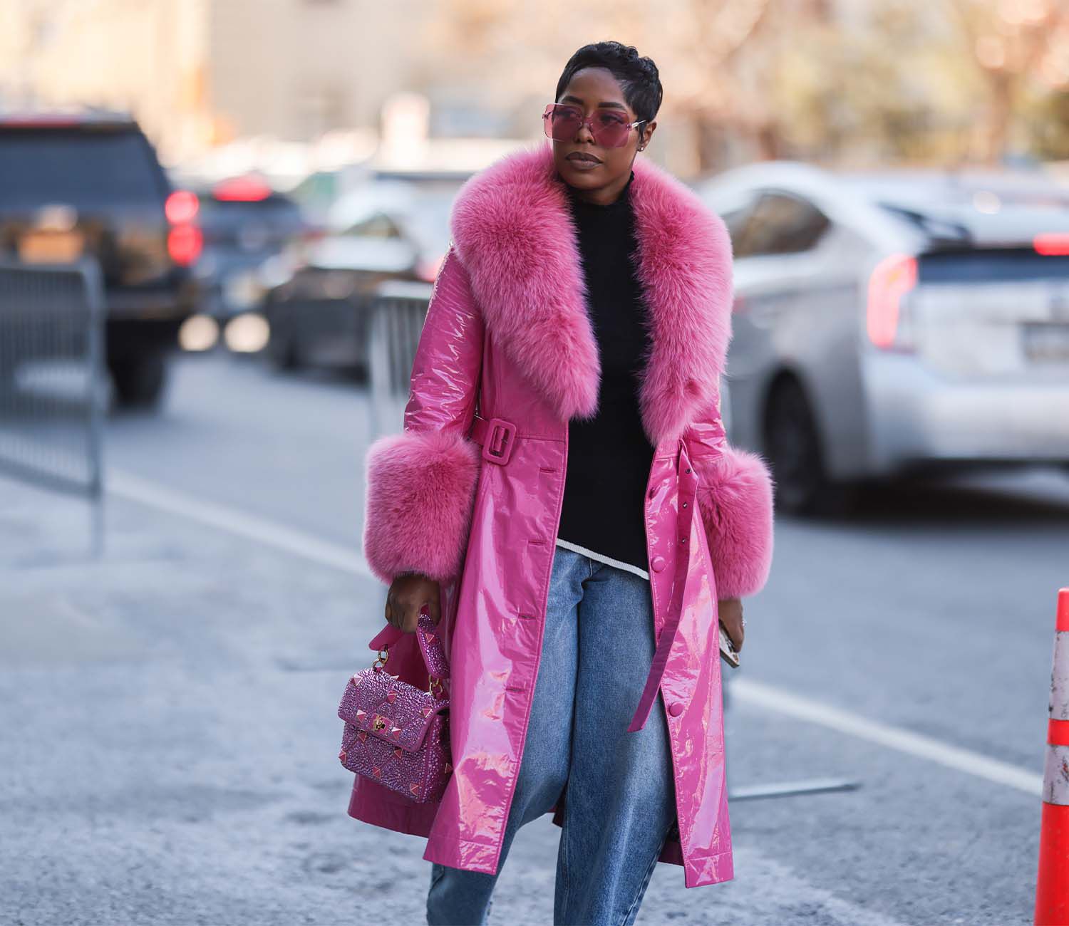 2022年2月，纽约时装周上，一名身穿粉色毛皮衬里外套、戴着粉色太阳镜的女子。