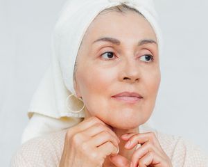 近距离拍摄一个60多岁的女人，头上戴着一条毛巾