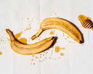 一个香蕉一分为二在白色背景下毛毛雨用蜂蜜