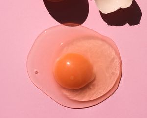 粉红色背景上有一颗开裂的鸡蛋