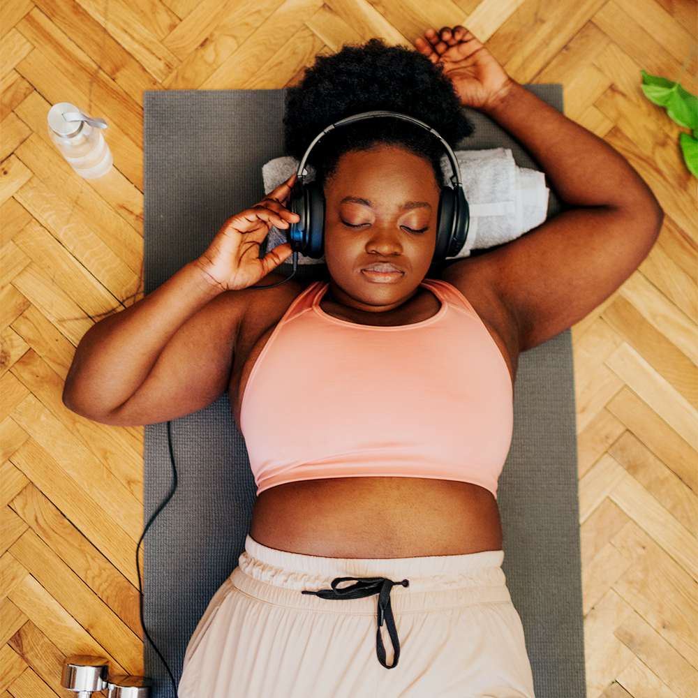 黑女人躺在垫子上锻炼后