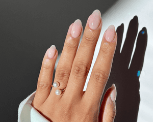 手上有淡粉色的指甲和珍珠开环