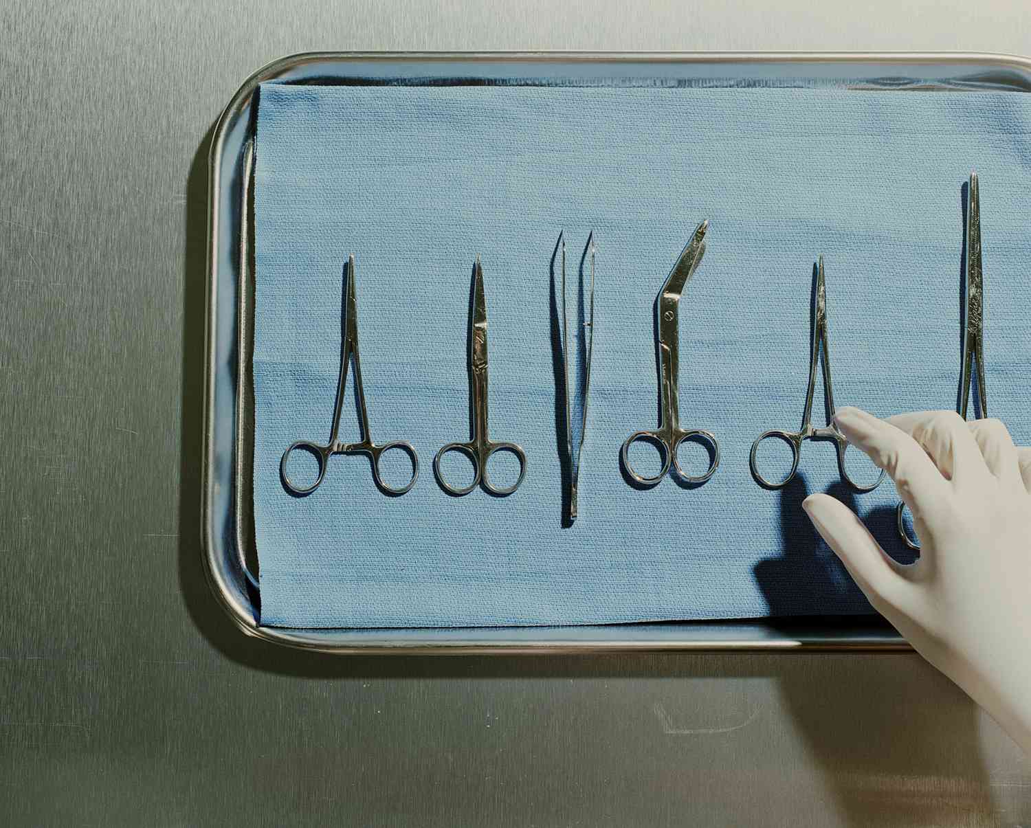 外科医生的手伸向手术工具