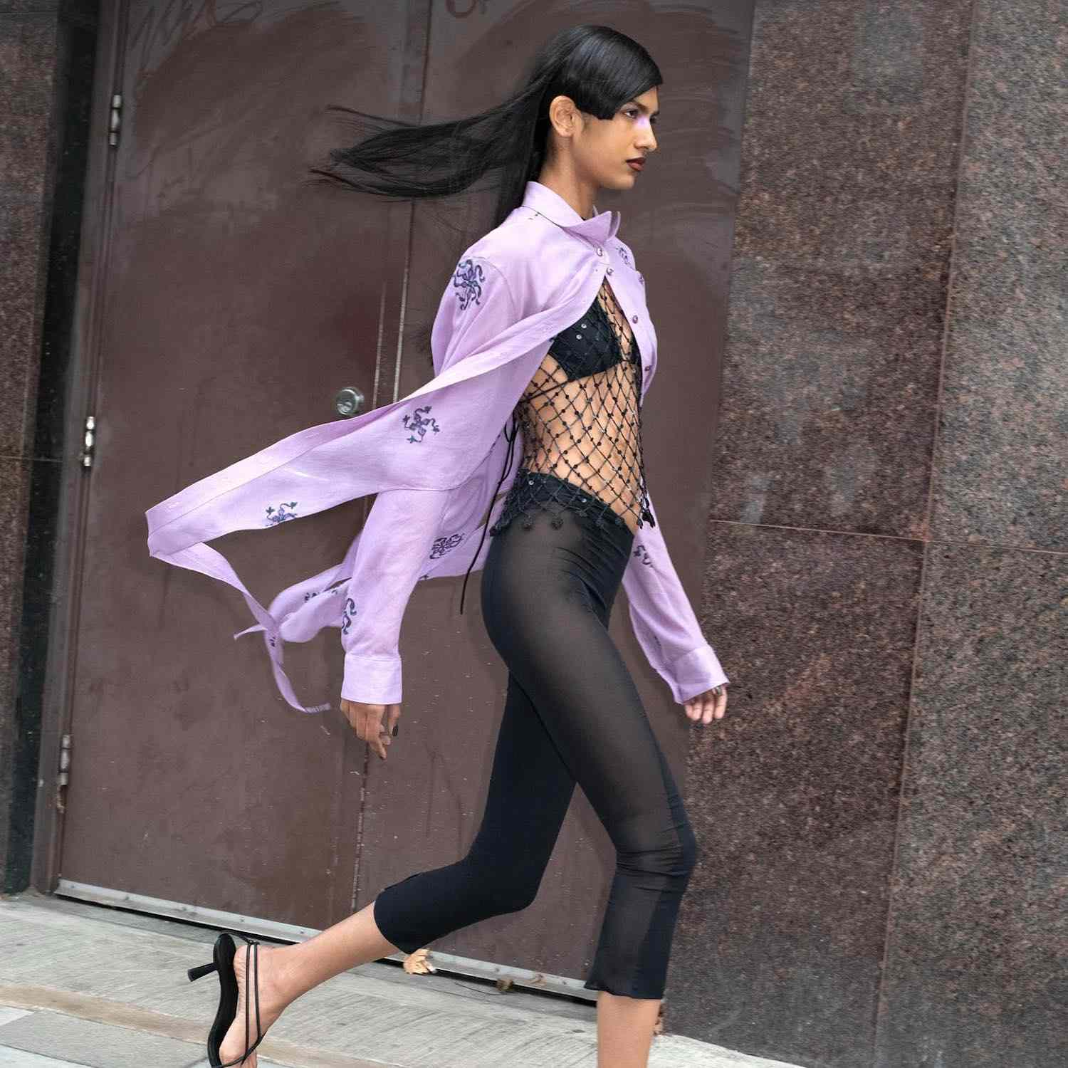 模特身穿由Supriya Lele设计的淡紫色系扣衬衫、黑色紧身裤和网眼上衣