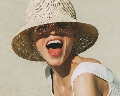 https://www.gettyimages.com/detail/photo/portrait-of-laughing-blond-woman-wearing-summer-hat-royalty-free-image/763162939
