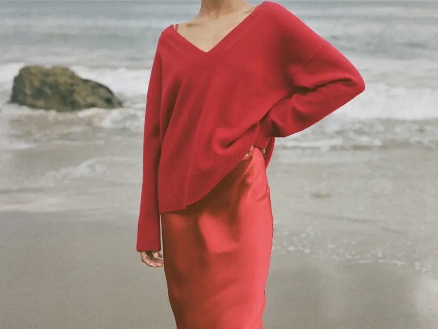 女人穿红色毛衣丝绸吊带裙在海滩