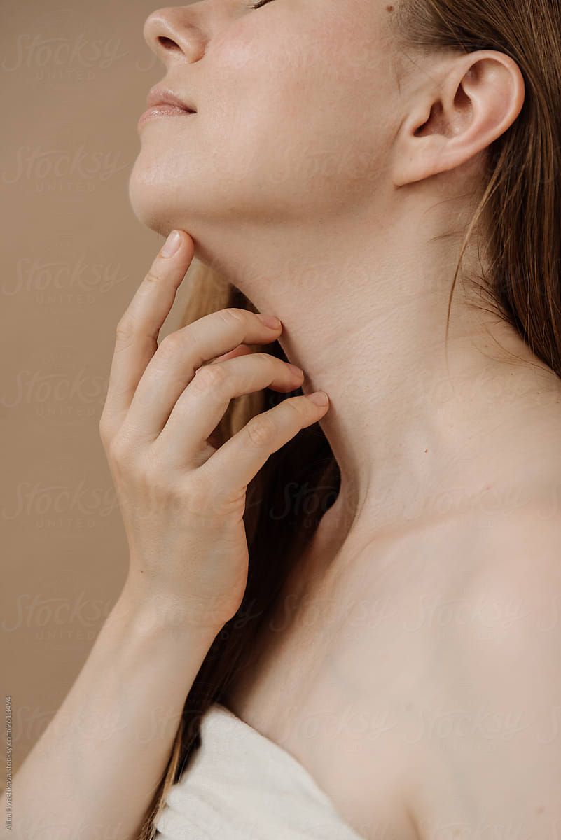 长头发的女人性感通过手指触摸脖子。”class=