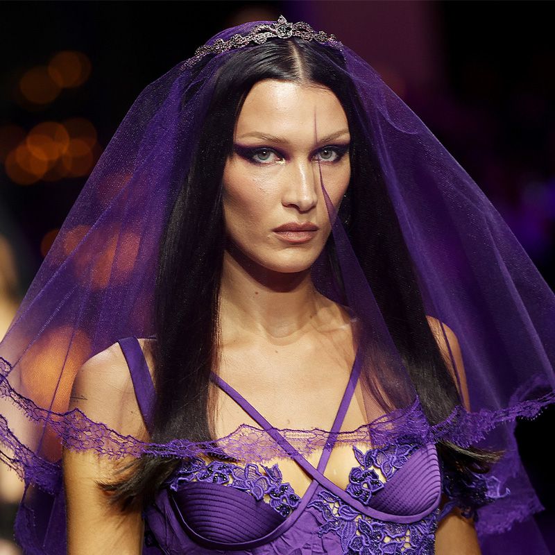 贝拉·哈迪德在范思哲SS23时装秀上戴着紫色面纱，画着眼妆