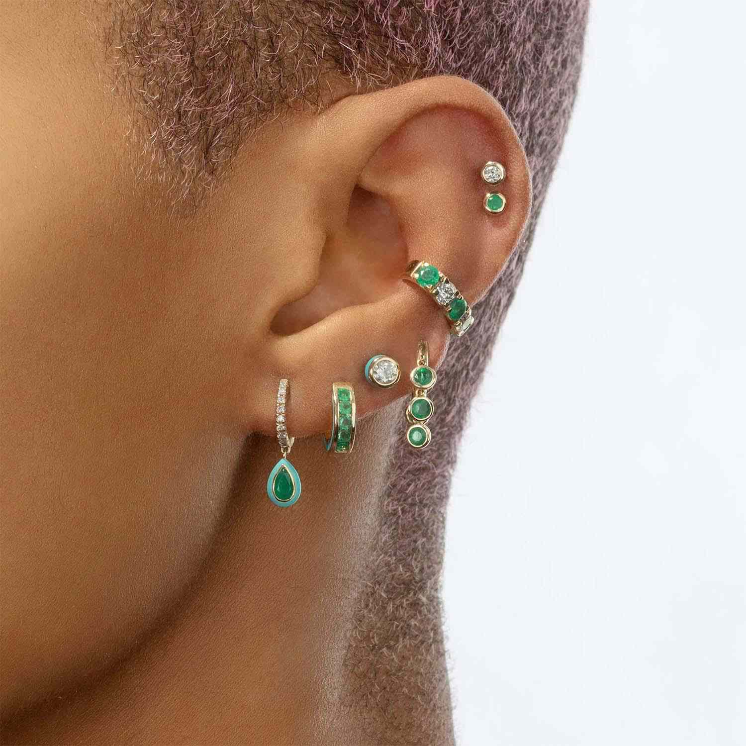 模特佩戴混合匹配绿色huggie耳环。